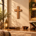 A wooden wall cross with a multi-layered inlay design in shades of brown and tan, mounted on a textured beige wall.