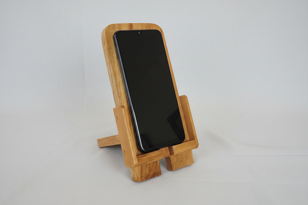 Wooden phone stand holding a smartphone on a white background