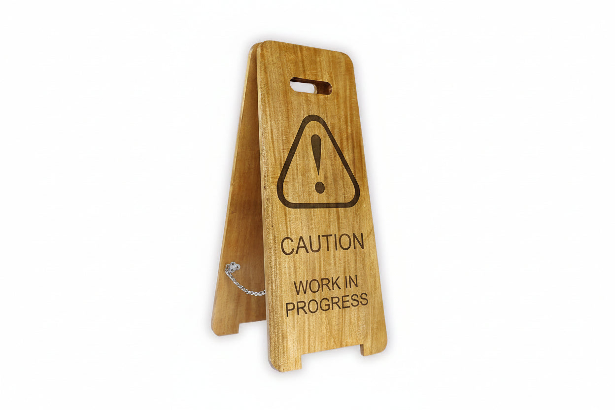 Wooden sign with caution symbol and text on a white background