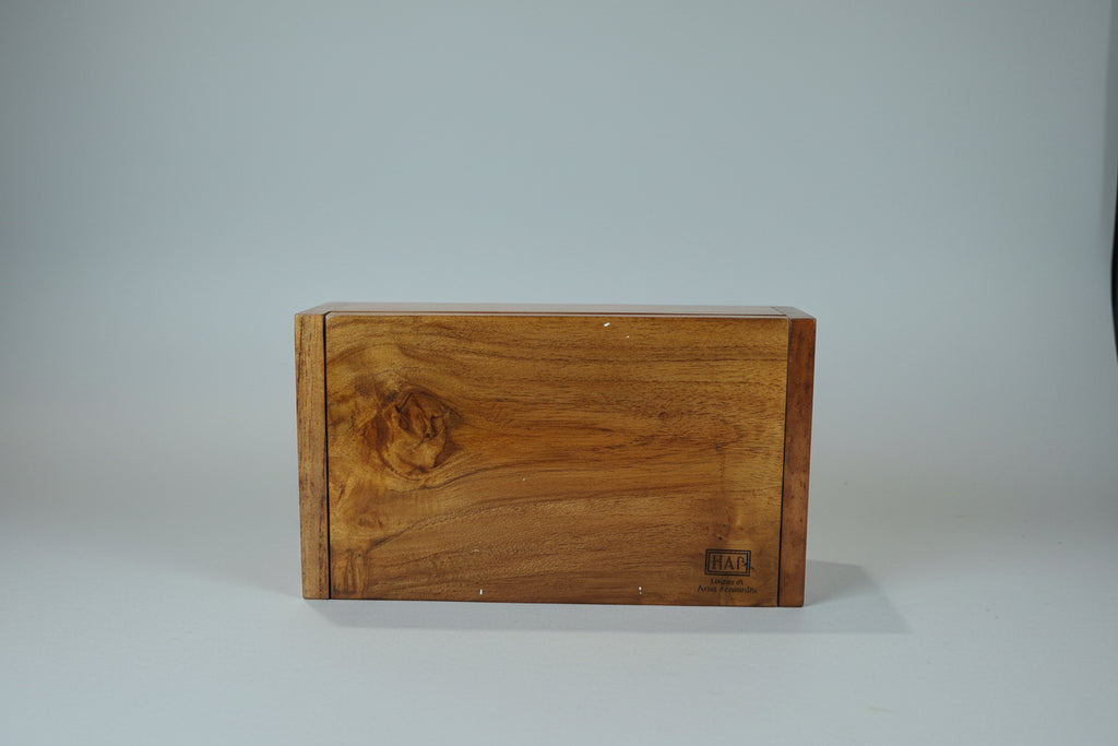 Wooden box with a brand logo on a table with a floral tablecloth