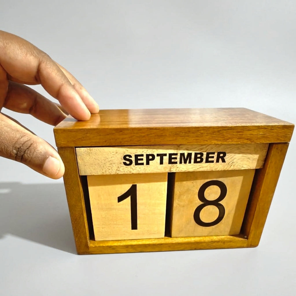 A wooden calendar block displaying September 18th, held by a hand on the top left corner, set against a plain white background.